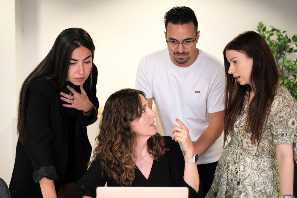 Andrea, Sara, Víctor y Vanessa frente al ordenador revisando un cliente de Lacomunicación